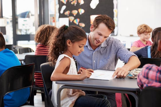 Male teacher helping girl